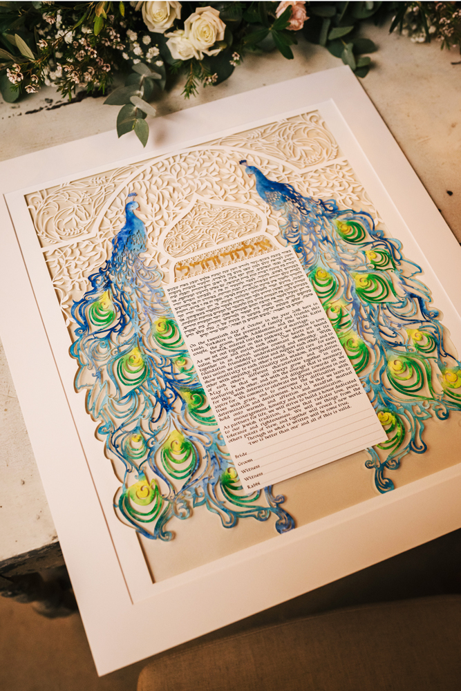 A photo of a beautifully handcrafted Ketubah highlighting the intricate artwork.